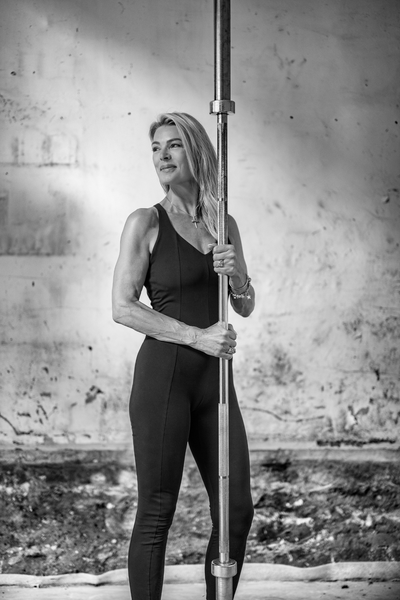 Ilse in een zwarte sportoutfit met een halterstang, zwart-wit