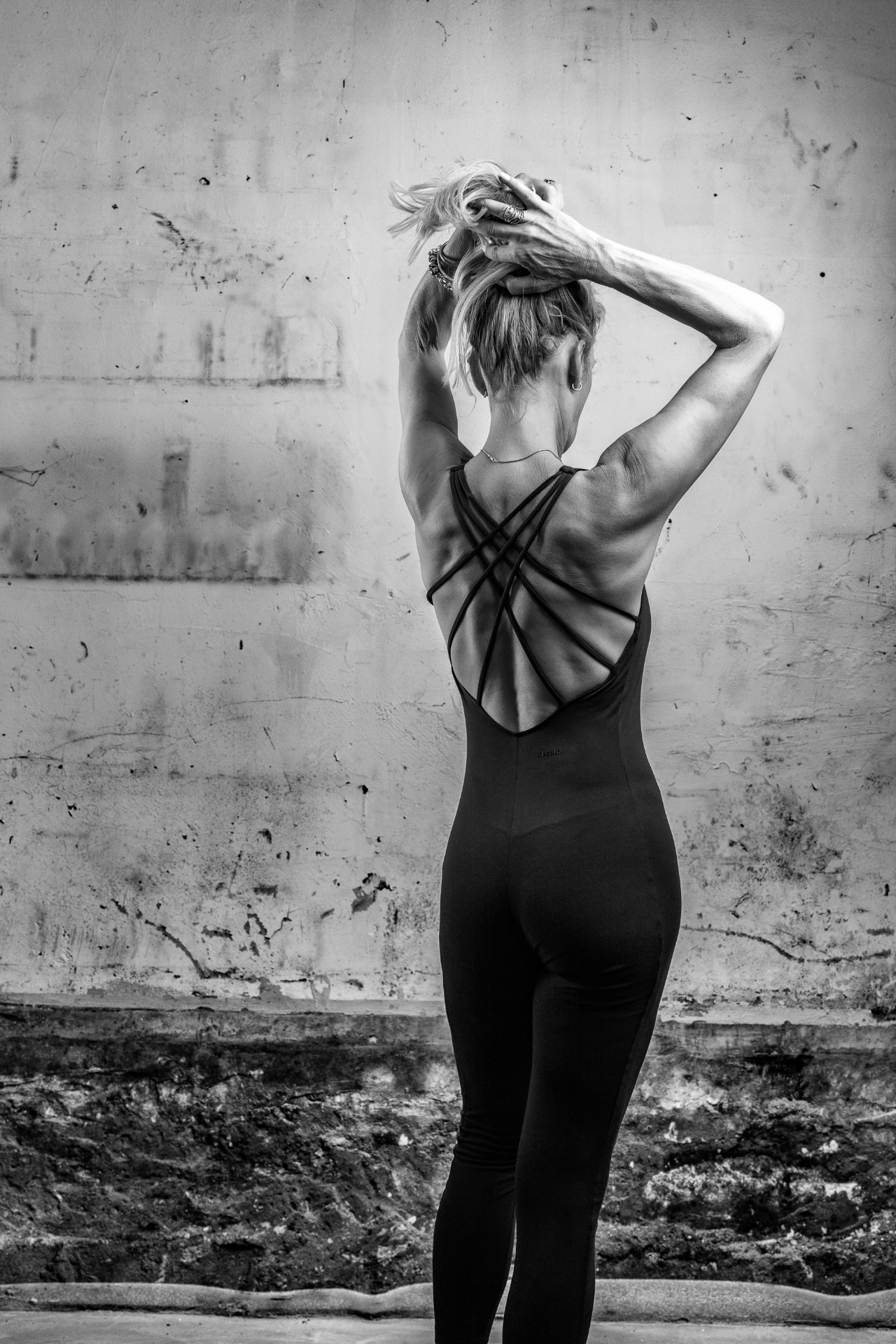 Ilse van achteren in een zwarte sportoutfit, zwart-wit